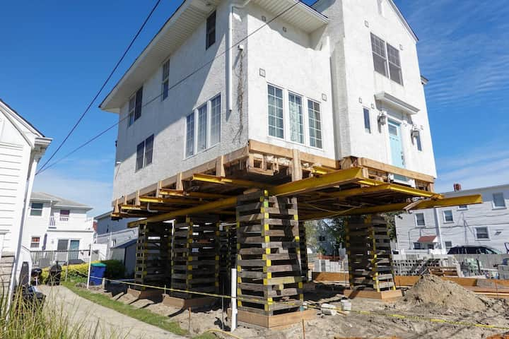 A team of professionals using specialized equipment to raise a house in Salisbury, preparing it for elevation and renovation